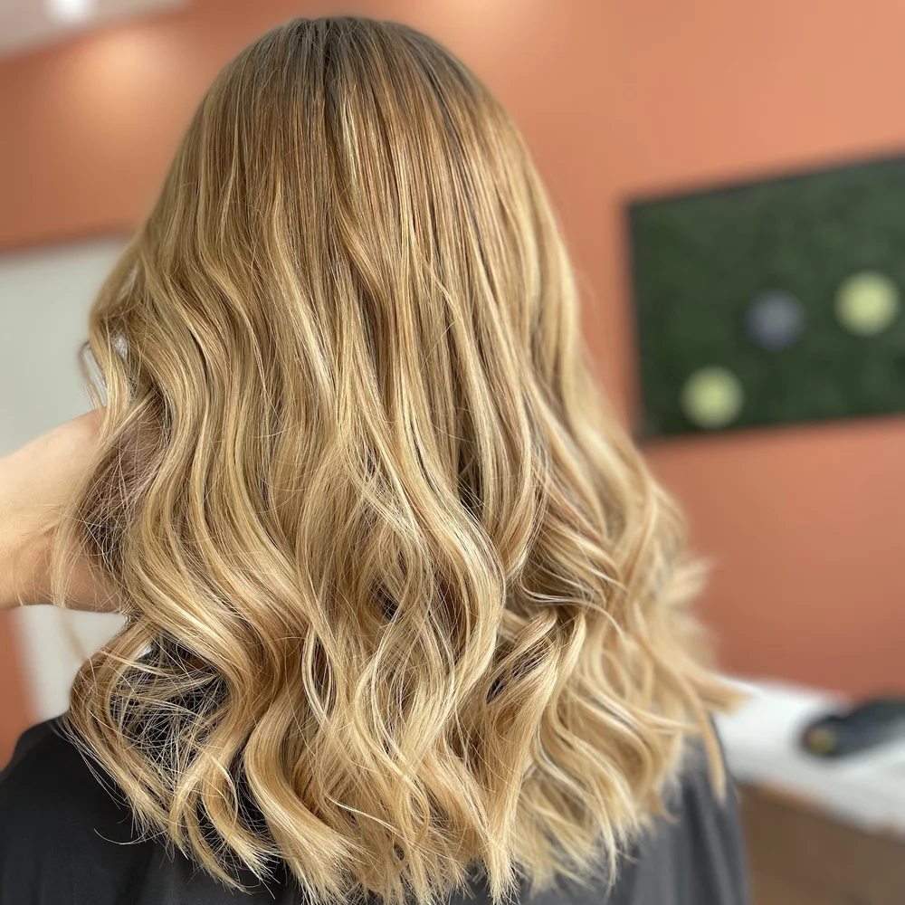 Balayage blond ondulé réalisé chez Machin Coiffure, coiffeur à Calais