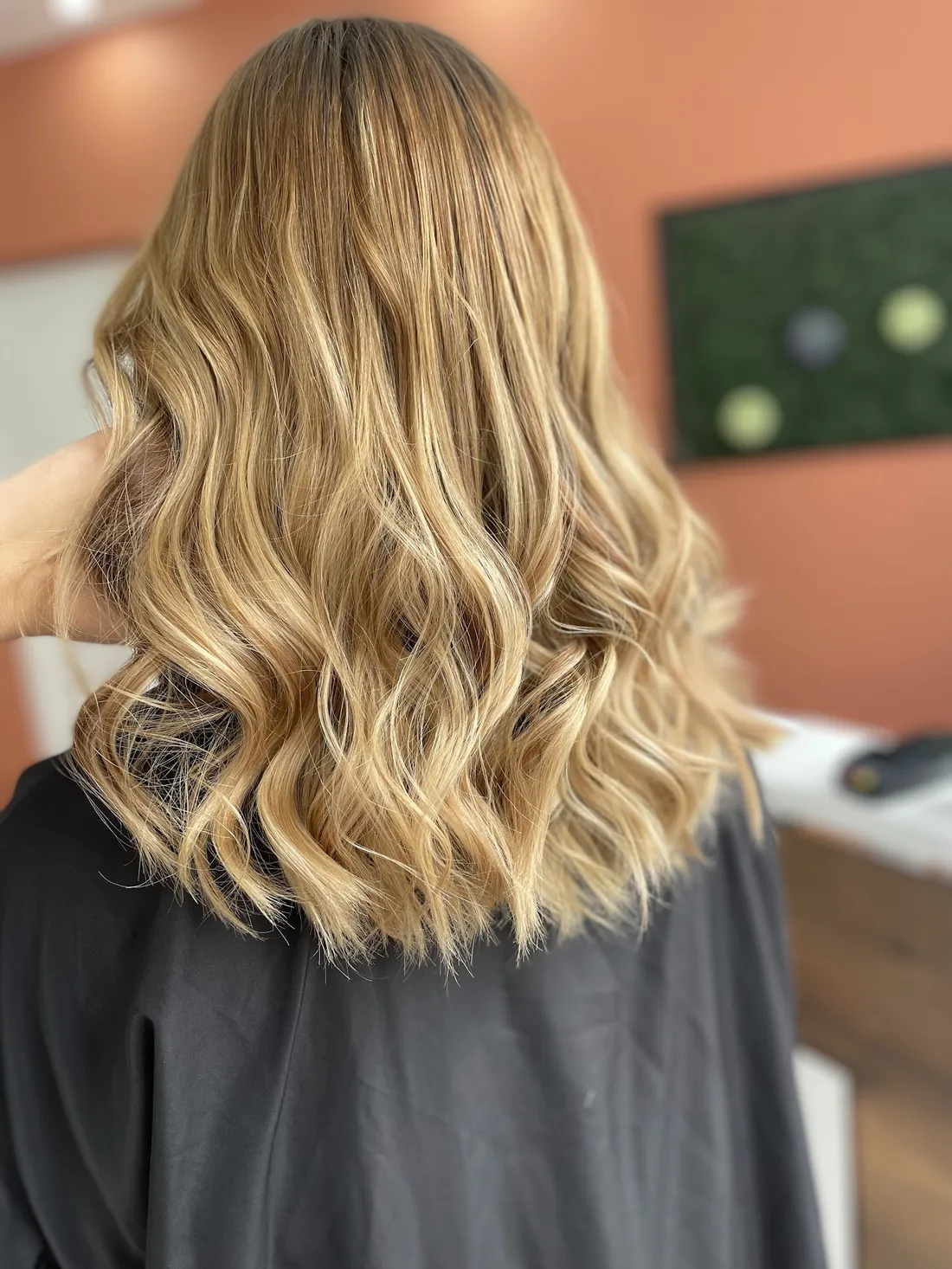Cheveux longs ondulés blonds coiffés chez Machin Coiffure à Calais